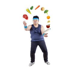 Fat man juggling healthy food