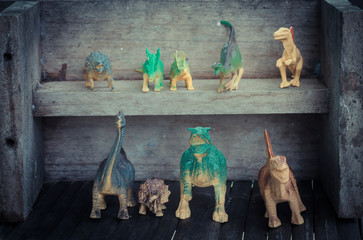 Dinosaurs on wooden shelf in vintage style