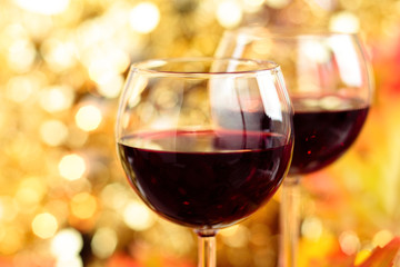 Fresh wine against autumnal lights background.