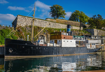 Old fishing boat and Akershus Fortress, Oslo, Norway