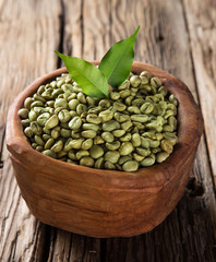 green coffee beans in wooden bowl