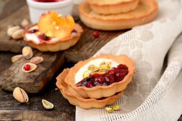 tartlets with cream, berry sauce and pistachios