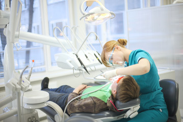 Modern dental clinic, young dentist working