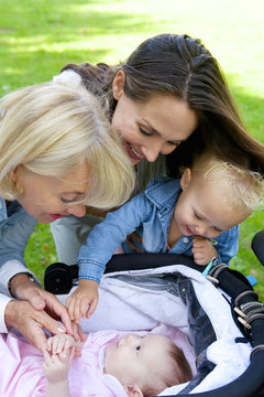 Mother And Grandmother Smiling At Baby