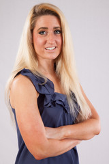 Blond woman in blue dress smiling at the camera