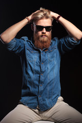 Obraz premium handsome man sitting and fixing his hair with both hands