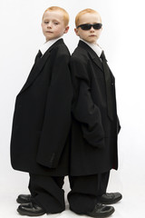 Seven year old twin boys dressed as gangsters or men in black.