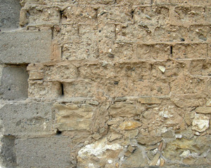 Edge of wall of mud bricks with straw and concrete bricks