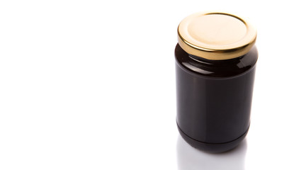 Bottled blueberry jam over white background