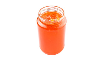 Orange fruit jam in a bottle over white background