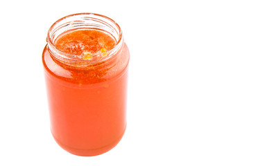 Orange fruit jam in a bottle over white background