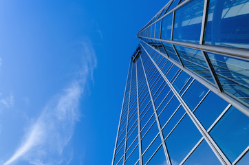Metal blue skyscrapper's windows against clear blue sky