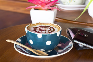 Coffee cup and smartphone on a wooden table