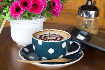 Coffee cup and smartphone on a wooden table