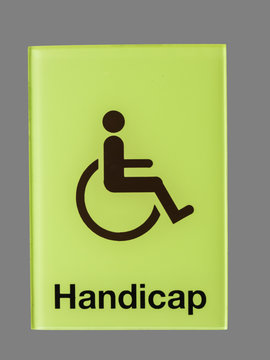 Green glass handicap sign isolated on grey  background