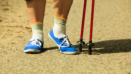 Fototapeta na wymiar active woman senior nordic walking in park. legs
