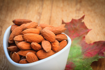 Almonds in bowl on autumnal background