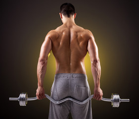 Rear view of a fitness man lifting weights with curl bar