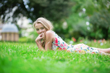 Naklejka na ściany i meble Beautiful young girl lying on the grass