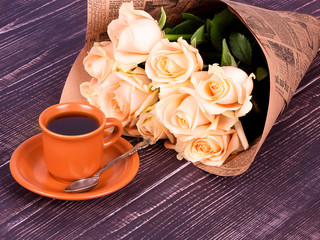 Cup of coffee and roses over wooden background