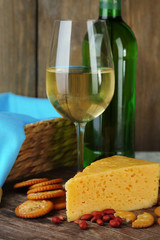 Wine, cheese and crackers on wooden table close-up