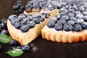 Tasty homemade pie with blueberries on wooden table