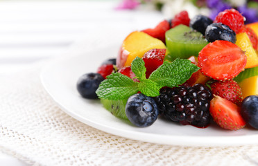 Delicious fruits salad in plate on table close-up