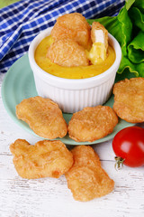 Chicken nuggets with sauce on table close-up