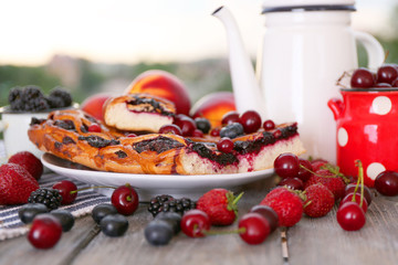 Sweet berry tart with berries on table on natural background