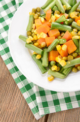Delicious vegetables salad on plate on table close-up