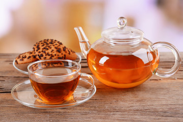Teapot and cup of tea on table on light background