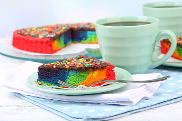 Delicious rainbow cake on plate, on table, on light background