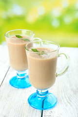 Delicious berry mousse in glasses on table on bright background