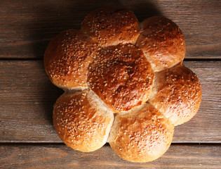 Tasty buns with sesame on  wooden background