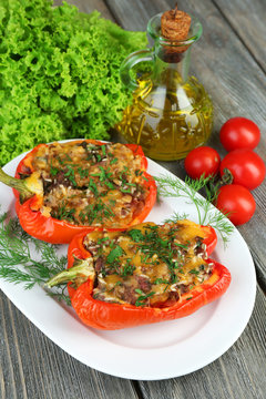 Stuffed red peppers with greens and vegetables on table close
