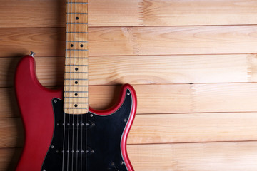 Red guitar on wooden background