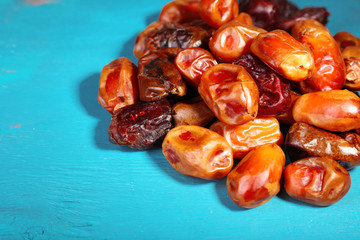 Tasty dates fruits on blue wooden table
