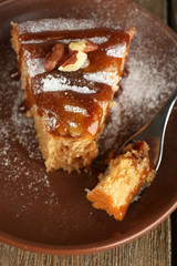 Half eaten delicious cake piece on plate on wooden table