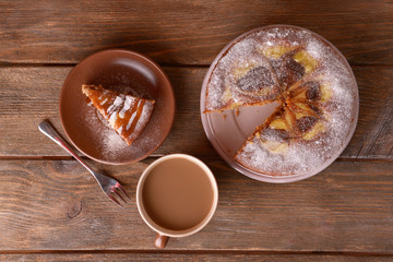 Delicious cake and cup of coffee on wooden table