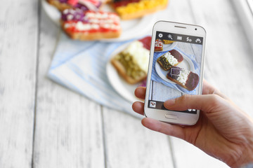 Hand making photo of sandwiches with flags