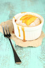 Tasty mini cake with fresh peach, on wooden table