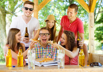 Friends drinking and eating pizza