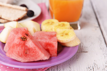 Slices of fruits with crispbreads and glass of juice