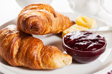 Fresh croissants with butter and a glass of milk