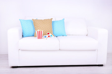 Popcorn and 3D glasses on sofa in room