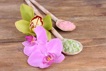 Tropical orchid flowers and sea salt in wooden spoons