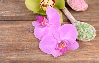 Tropical orchid flowers and sea salt in wooden spoons