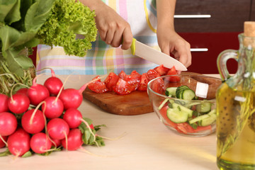 Woman cooking vegetable salad in kitchen