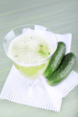 Cucumber cocktail on napkin on wooden background