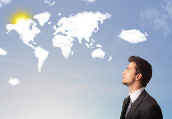 Businessman looking at world clouds and sun on blue sky